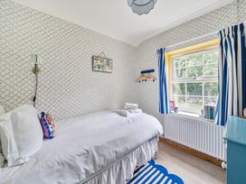 A bedroom with a bed and window at Bodior Lodge, Rhoscolyn