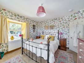 A bedroom with a bed and floral wallpaper at Bodior Lodge in Rhoscolyn