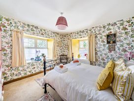 A bedroom with a bed and windows at Bodior Lodge in Rhoscolyn