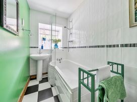 A bathroom with a bathtub, sink, and shower at Bodior Lodge in Rhoscolyn