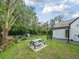 A garden with a picnic table and trees at Bodior Lodge Rhoscolyn