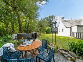 A garden with a hot tub and seating area at Bodior Lodge in Rhoscolyn
