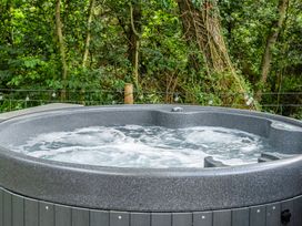 A hot tub with water in an outdoor area at Bodior Lodge Rhoscolyn