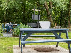 A picnic table and garden chairs in a garden at Bodior Lodge in Rhoscolyn