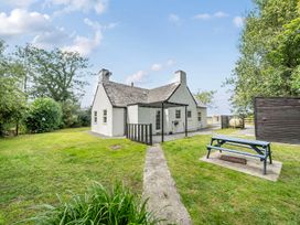 A house with a garden and picnic table at Bodior Lodge Rhoscolyn