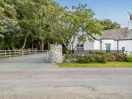 An outdoor view of a house with a gate and trees at Bodior Lodge in Rhoscolyn