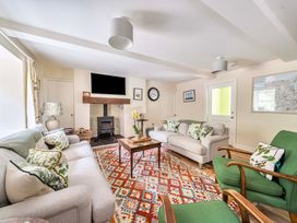 A living room with a fireplace and sofa at Bodior Garden Cottage in Rhoscolyn