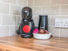 A coffee machine and milk frother on a kitchen counter at Bodior Garden Cottage Rhoscolyn