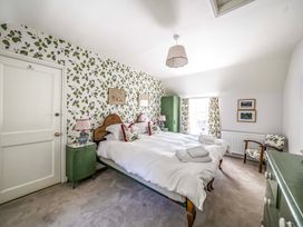 A bedroom with a large bed and green furniture at Bodior Garden Cottage in Rhoscolyn