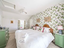A bedroom with a double bed and green chest of drawers at Bodior Garden Cottage in Rhoscolyn