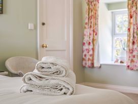 A bedroom with towels on a bed at Bodior Garden Cottage in Rhoscolyn