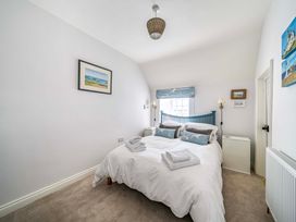 A bedroom with a bed and window at Bodior Garden Cottage Rhoscolyn