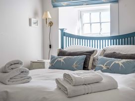 A bedroom with towels on the bed at Bodior Garden Cottage in Rhoscolyn