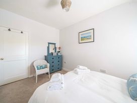 A bedroom with a bed and dresser at Bodior Garden Cottage Rhoscolyn