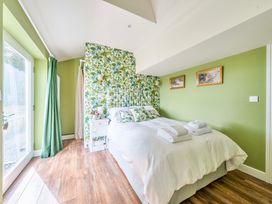 A bedroom with a bed and bedside table at Bodior Garden Cottage in Rhoscolyn