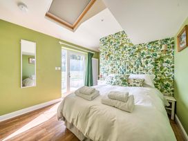A bedroom with a bed and mirror at Bodior Garden Cottage Rhoscolyn
