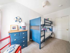 A bedroom with bunk beds and a chest of drawers at Bodior Garden Cottage in Rhoscolyn