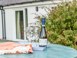 A bottle of prosecco and glasses on a table at Bodior Garden Cottage in Rhoscolyn
