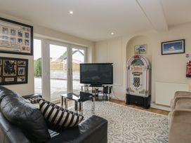 A living room with a television and jukebox at Whimhowe in Windermere