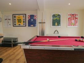 A games room with a pool table and framed sports jerseys at Whimhowe in Windermere