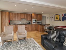A living room with kitchen cabinets and seating area at Whimhowe in Windermere