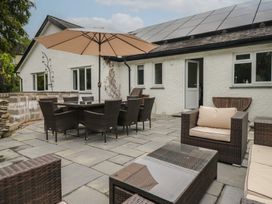 An outdoor patio with furniture and an umbrella at Whimhowe in Windermere