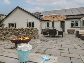 A patio with fire pit and seating area at Whimhowe in Windermere