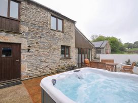 An outdoor area with a hot tub and seating at The Dairy Barn in Camelford
