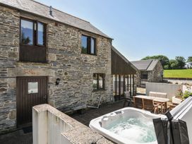 An outdoor area with a hot tub and seating at The Dairy Barn in Camelford