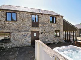 An outdoor view of a stone building with a spa at The Dairy Barn Camelford