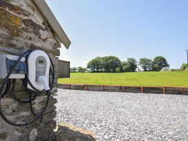 An electric vehicle charger on a gravel surface in an outdoor area at The Dairy Barn in Camelford