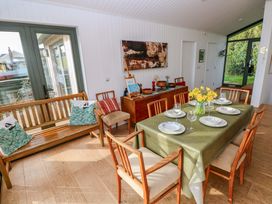 A dining room with a table set for a meal at Green Shutters in Freshwater East near Lamphey