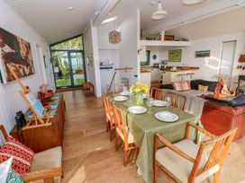 A living room with a dining table and sofa at Green Shutters Freshwater East near Lamphey