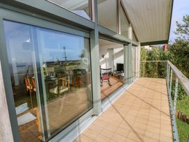 A living room with a deck view at Green Shutters in Freshwater East near Lamphey