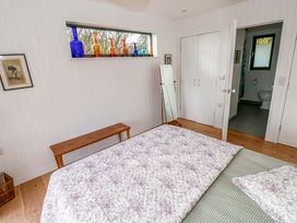 A bedroom with a bed and window at Green Shutters in Freshwater East near Lamphey