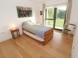 A bedroom with a bed and chair at Green Shutters Freshwater East near Lamphey