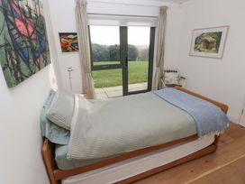 A bedroom with a bed and paintings on the wall at Green Shutters Freshwater East near Lamphey