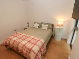 A bedroom with a bed and bedside table at Green Shutters in Freshwater East near Lamphey