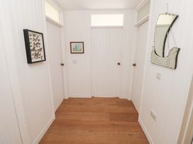 A hallway with butterfly frame and paintings at Green Shutters Freshwater East near Lamphey