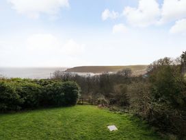 A garden view overlooking the ocean and hills at Green Shutters Freshwater East near Lamphey