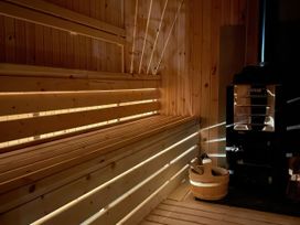 A sauna with wooden benches and a heater at Green Shutters in Freshwater East near Lamphey