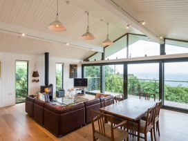 A living room with a couch and dining table at Green Shutters in Freshwater East near Lamphey