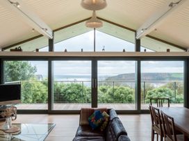 A living room with a sofa and dining table at Green Shutters near Freshwater East