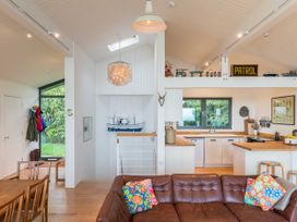 An open living area with a kitchen and dining table at Green Shutters in Freshwater East near Lamphey