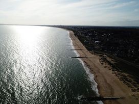 A long sandy beach with groynes stretching into the sea and a town along the coast at Bayview Cottage in Southbourne