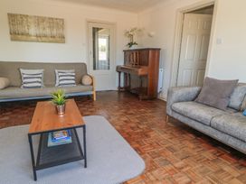A living room with a piano and sofa at Bayview Cottage in Southbourne