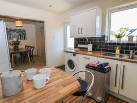 A kitchen with a washing machine and table at Bayview Cottage in Southbourne