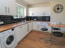 A kitchen with appliances and a bar table at Bayview Cottage in Southbourne