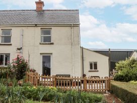 An exterior view of a house with a garden and fence at Aunty Junes Cottage Okehampton