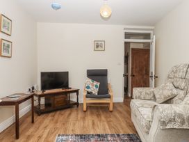 A living room with a television and chairs at Aunty Junes Cottage Okehampton
